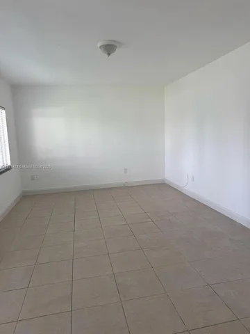 an empty room with white walls and windows