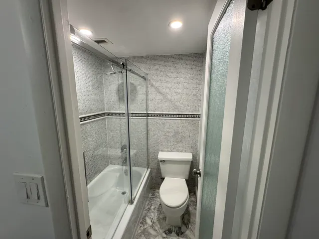 a bathroom with a toilet and a shower