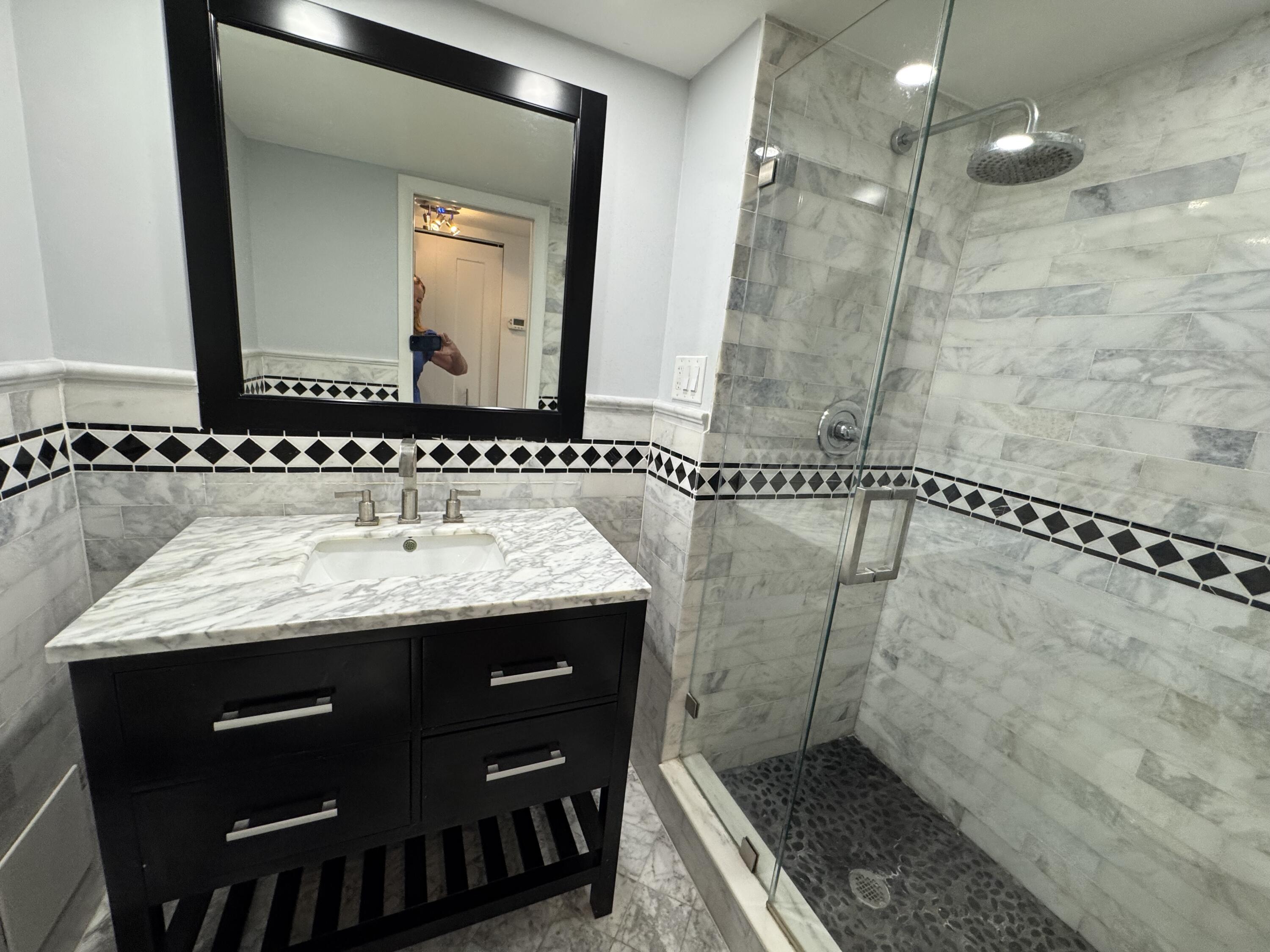 3540 South Ocean Boulevard, Unit 608 South Palm Beach, FL 33480 - Photo 13 of 35 a bathroom with a granite countertop sink a mirror and a shower
