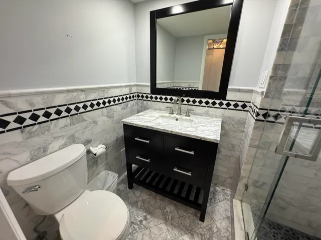 a bathroom with a toilet sink and mirror