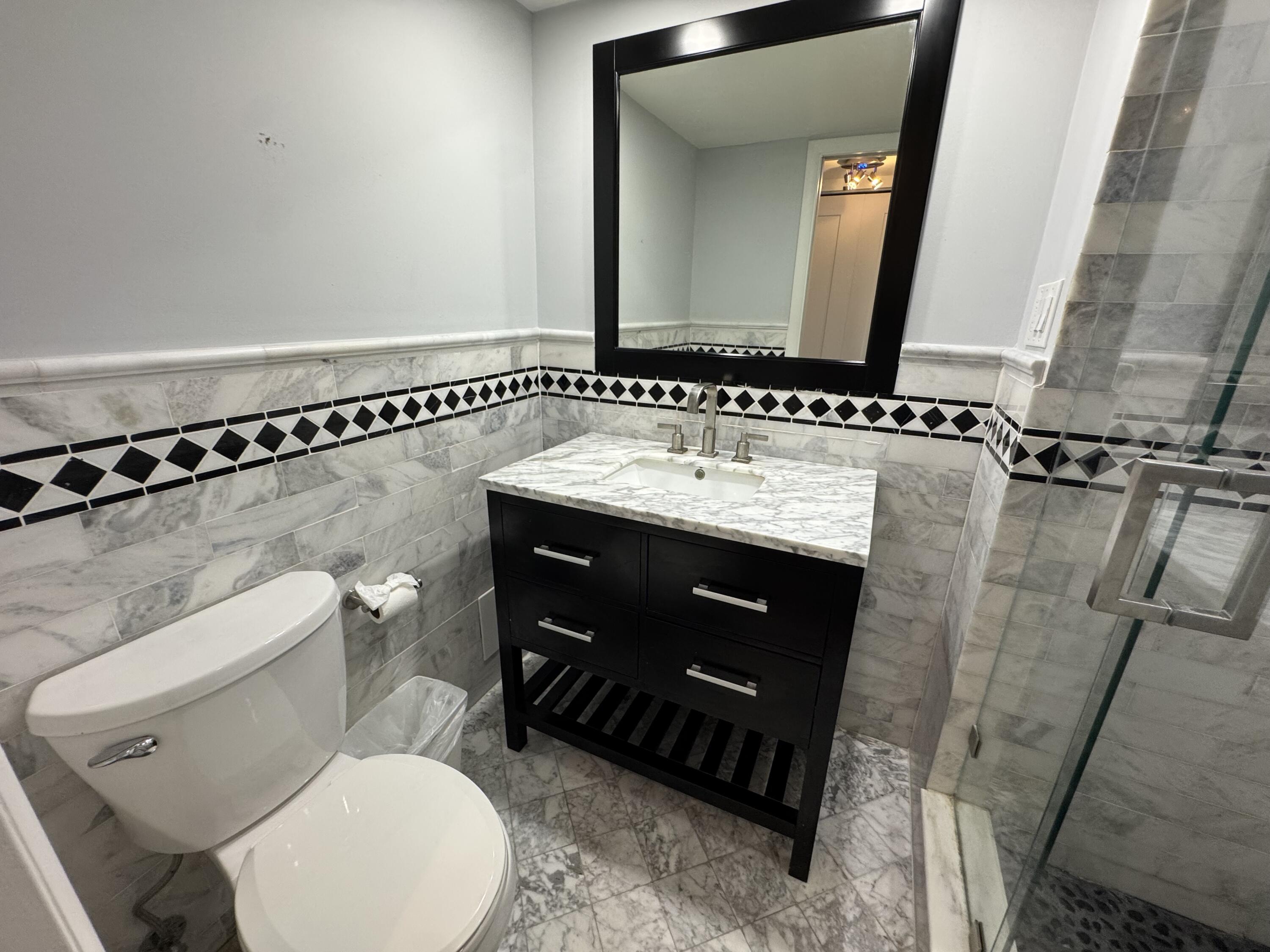 3540 South Ocean Boulevard, Unit 608 South Palm Beach, FL 33480 - Photo 14 of 35 a bathroom with a toilet sink and mirror