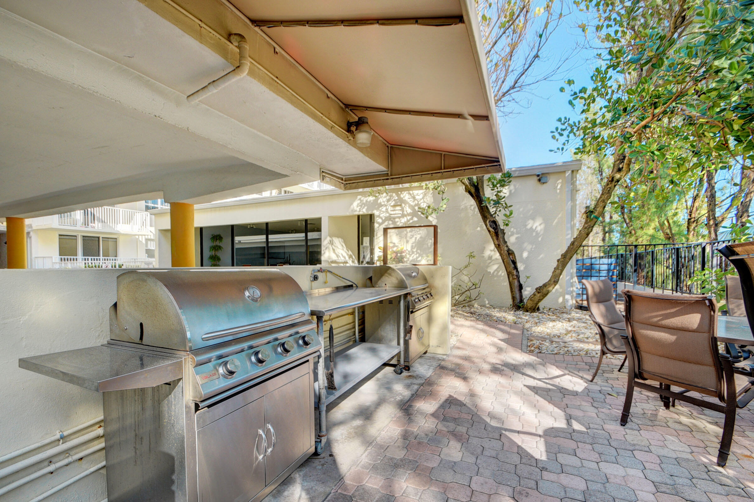 3540 South Ocean Boulevard, Unit 608 South Palm Beach, FL 33480 - Photo 19 of 35 a view of a patio with table and chairs with wooden floor and fence