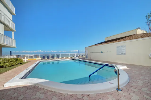 a view of a swimming pool with an outdoor seating and a balcony