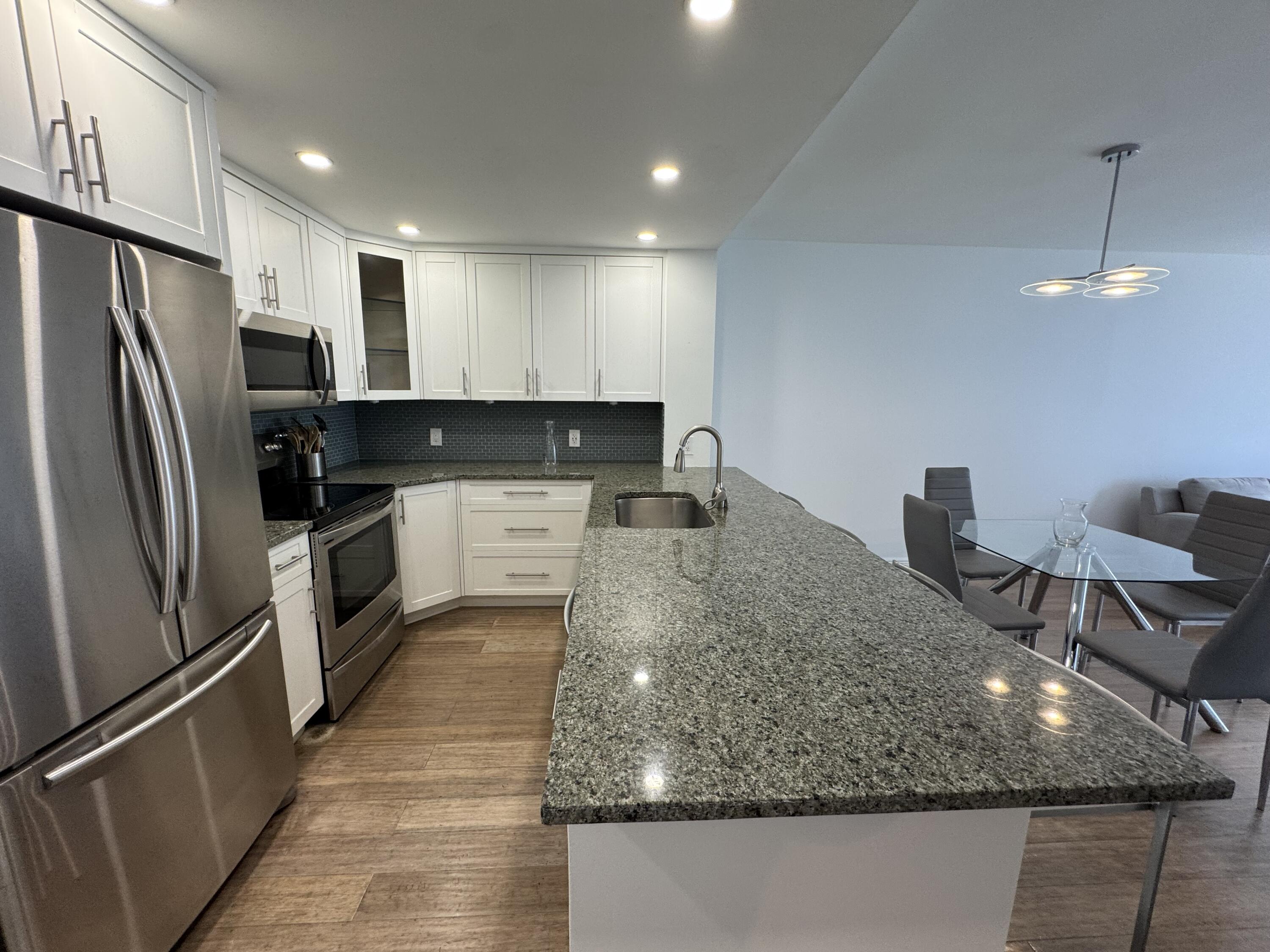 3540 South Ocean Boulevard, Unit 608 South Palm Beach, FL 33480 - Photo 3 of 35 a kitchen with stainless steel appliances granite countertop a sink refrigerator and cabinets