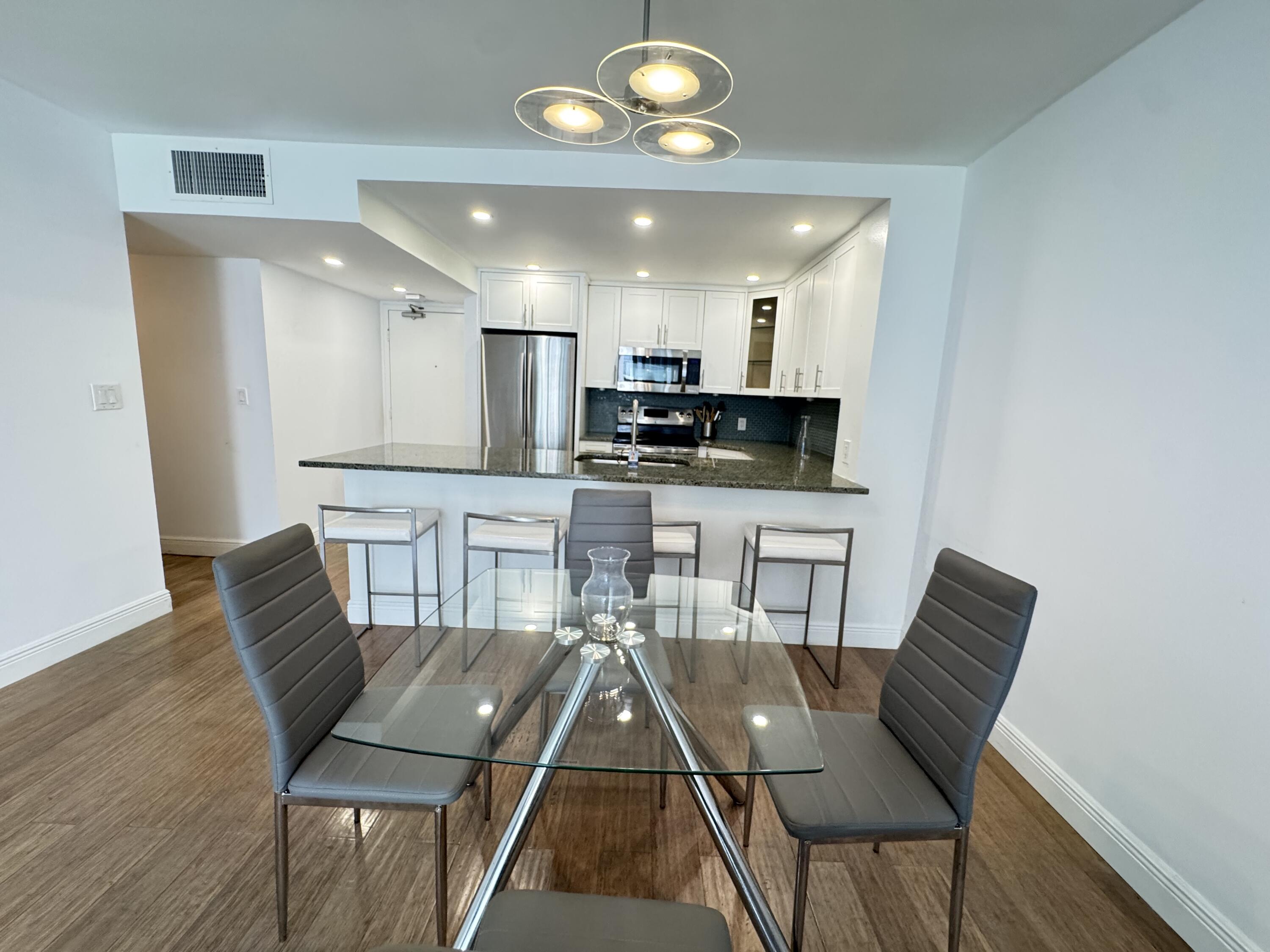 3540 South Ocean Boulevard, Unit 608 South Palm Beach, FL 33480 - Photo 7 of 35 a view of a dining room with furniture and wooden floor