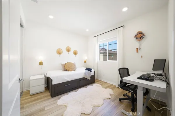 a bedroom with a bed and a potted plant