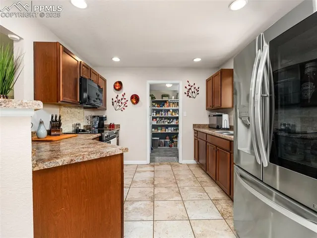 a kitchen with stainless steel appliances granite countertop a refrigerator and a stove top oven