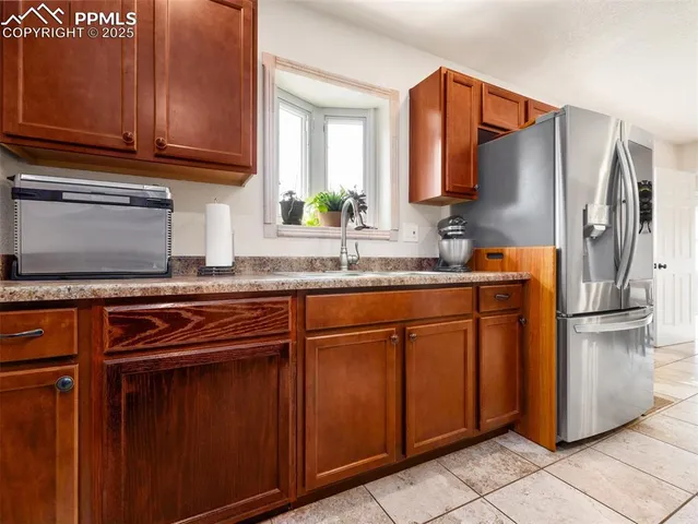 a kitchen with stainless steel appliances granite countertop a refrigerator and a sink