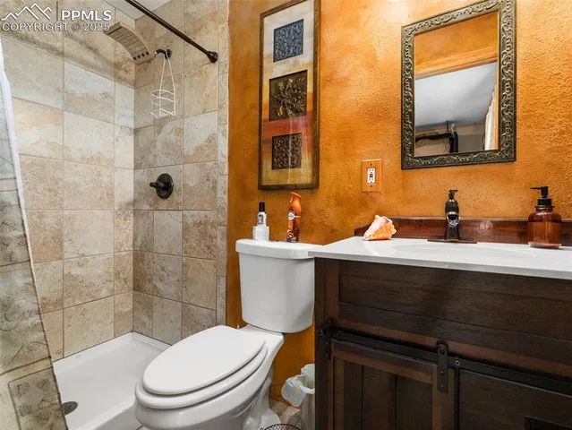 a bathroom with a sink a toilet a mirror and shower