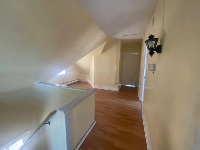 a view of an empty room with wooden floor