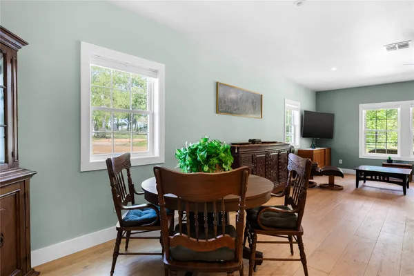 a kitchen with granite countertop a table chairs refrigerator and sink