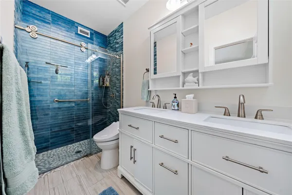 a bathroom with a sink a toilet and shower