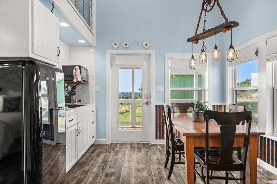 365 Billy Sisson Road Johnson City, TX 78636 - Photo 14 of 40 a kitchen with stainless steel appliances a dining table chairs refrigerator and cabinets