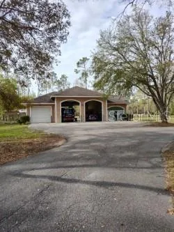 a front view of house with yard and trees around