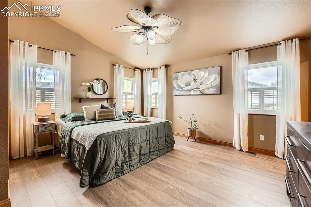 151 Star View Circle Palmer Lake, CO 80133 - Photo 15 of 36 Bedroom with light wood finished floors, lofted ceiling, a ceiling fan, and baseboards