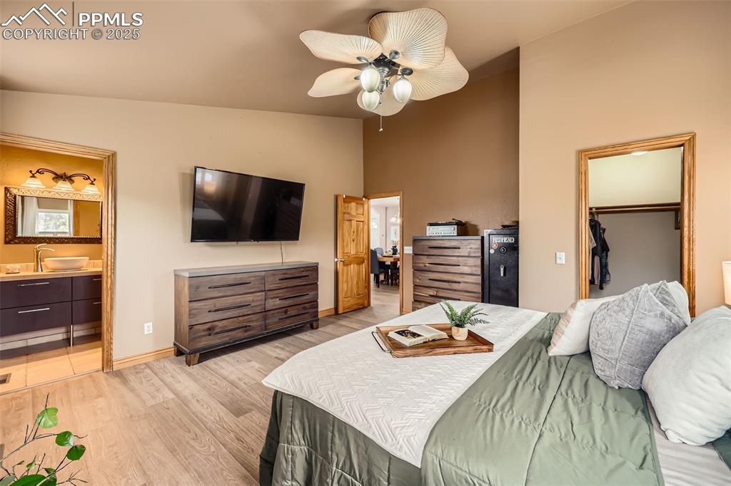 151 Star View Circle Palmer Lake, CO 80133 - Photo 17 of 36 Bedroom with light wood-type flooring, ensuite bath, baseboards, a closet, and a spacious closet