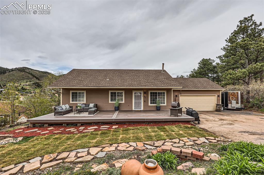 151 Star View Circle Palmer Lake, CO 80133 - Photo 2 of 36 Front view of house with an attached garage, concrete driveway, an outdoor hangout area, and a yard