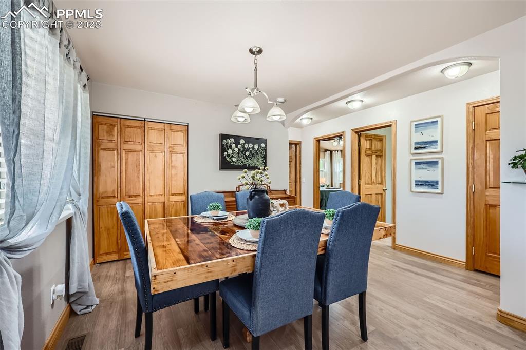 151 Star View Circle Palmer Lake, CO 80133 - Photo 10 of 36 Dining room with arched walkways, light wood-type flooring, and baseboards