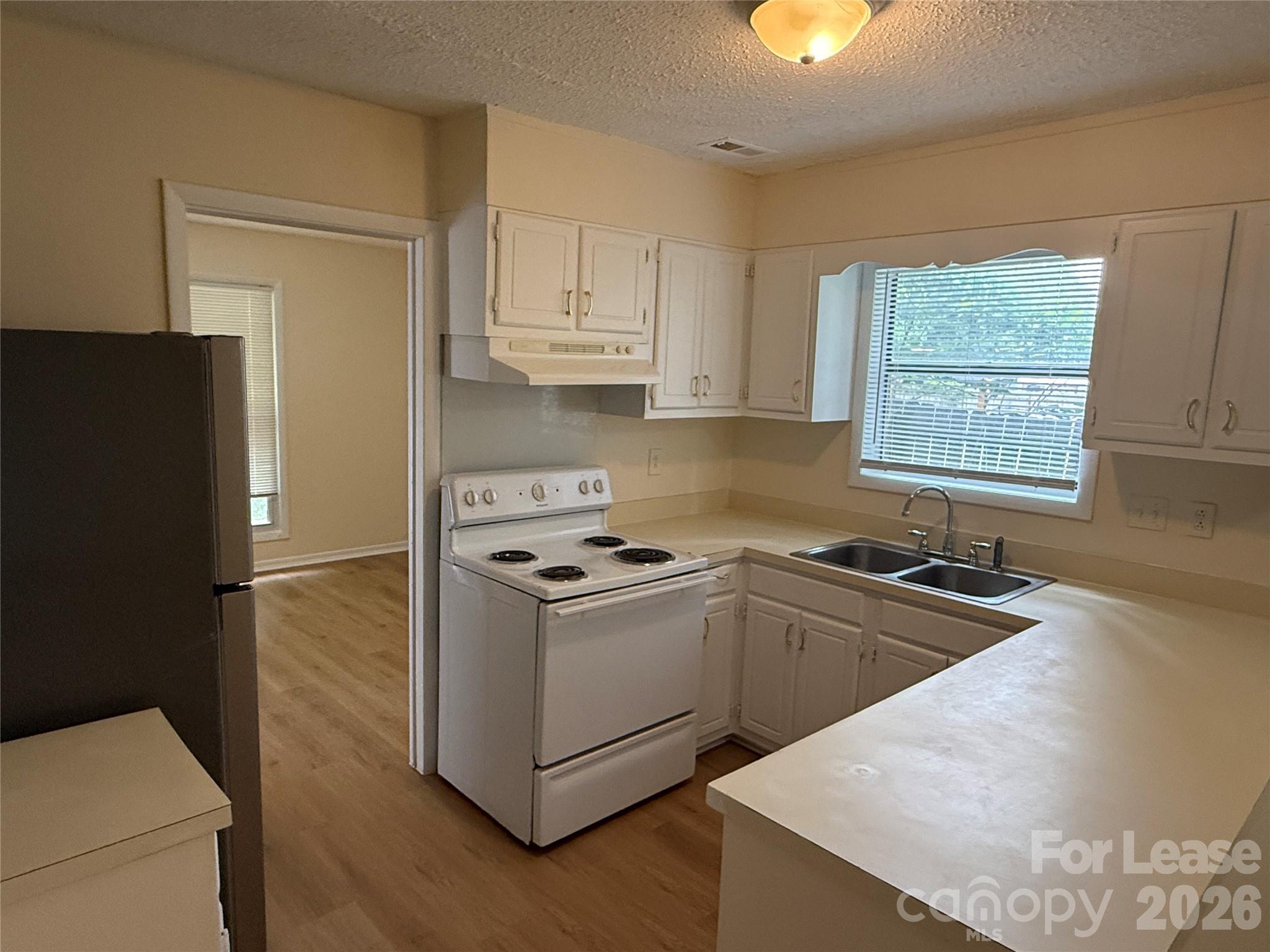 6341 Round Hill Road Charlotte, NC 28211 - Photo 4 of 16 a kitchen with granite countertop a sink stove and refrigerator