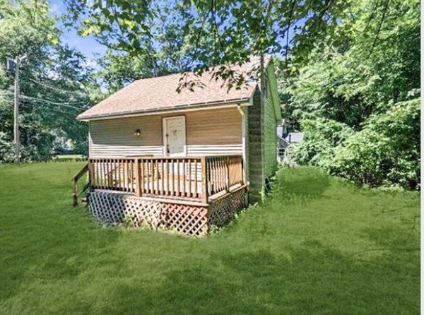 a view of a house with a yard and deck