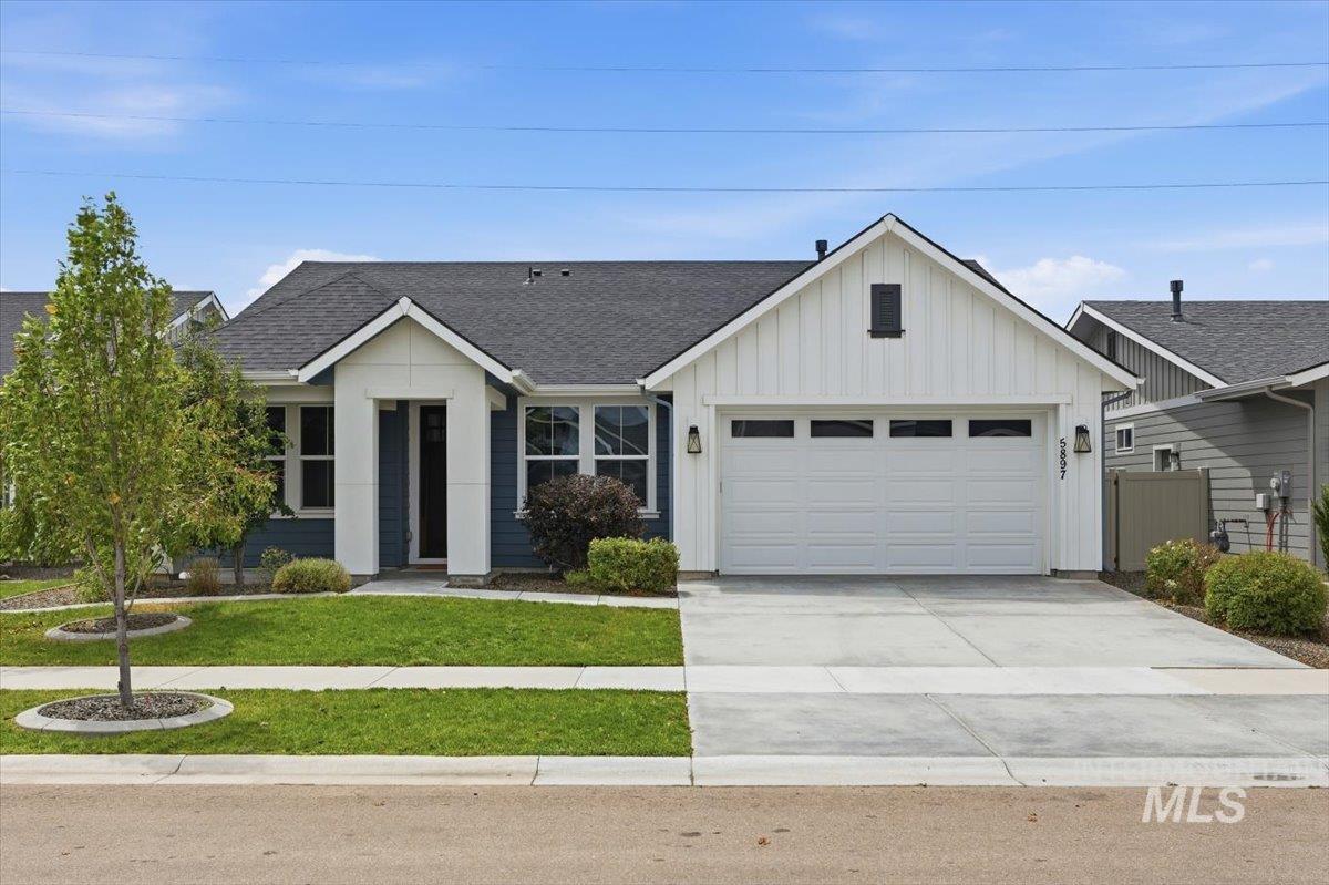 5897 West Riva Capri Street Meridian, ID 83646 - Photo 34 of 50 Modern farmhouse-style exterior with dark blue horizontal siding and white vertical board-and-batten accents
