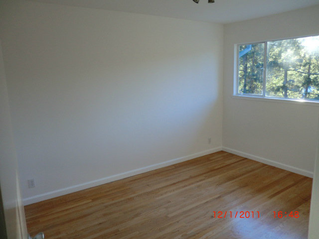 1247 Aspen Drive Pacifica, CA 94044 - Photo 2 of 12 a view of an empty room with wooden floor and a window