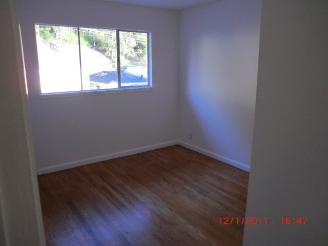 1247 Aspen Drive Pacifica, CA 94044 - Photo 5 of 12 an empty room with wooden floor and windows