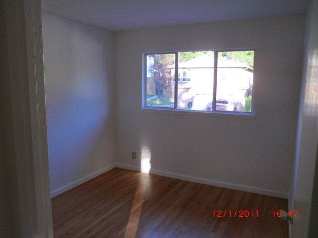 1247 Aspen Drive Pacifica, CA 94044 - Photo 6 of 12 an empty room with wooden floor and windows