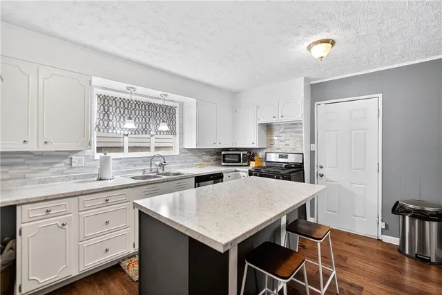 a kitchen with a sink stove and cabinets