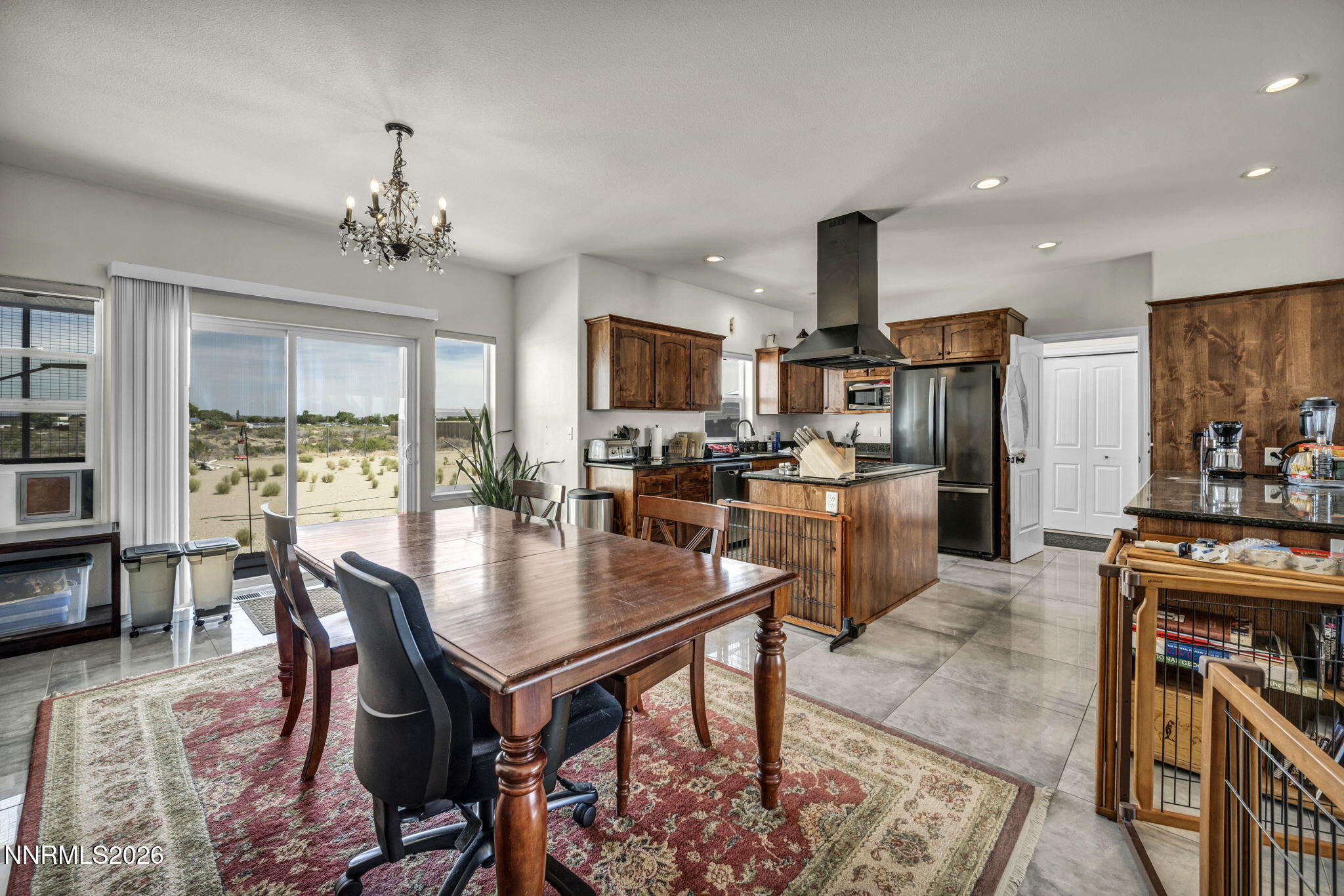 1286 Sky Ridge Drive Fallon, NV 89406 - Photo 19 of 49 a kitchen with stainless steel appliances kitchen island granite countertop a table chairs and a refrigerator