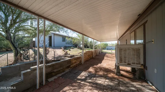a view of a swimming pool with a bench and trees in the background