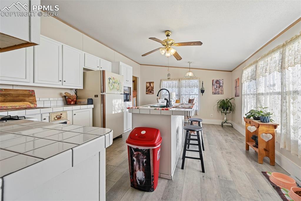 35875 Shear Road Yoder, CO 80864 - Photo 17 of 45 a kitchen with stainless steel appliances granite countertop a refrigerator a stove a sink dishwasher and white cabinets with wooden floor