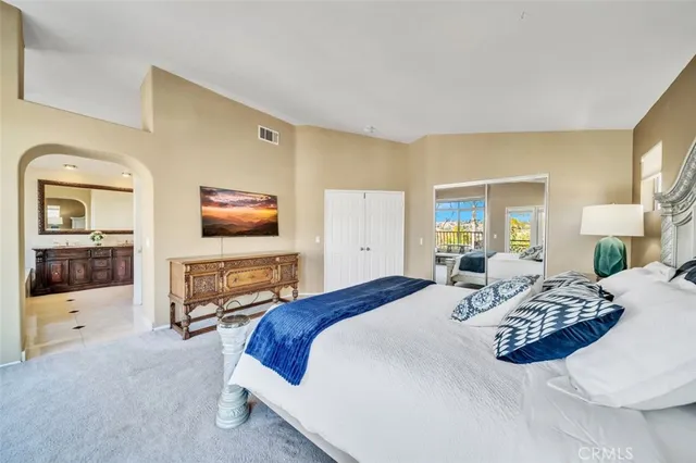 a bedroom with a large bed and a flat screen tv