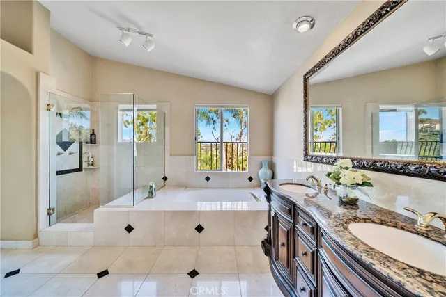 a spacious bathroom with double vanity sink a mirror and a shower