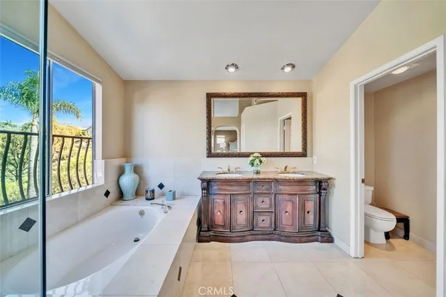 a spacious bathroom with a tub double sink window and mirror