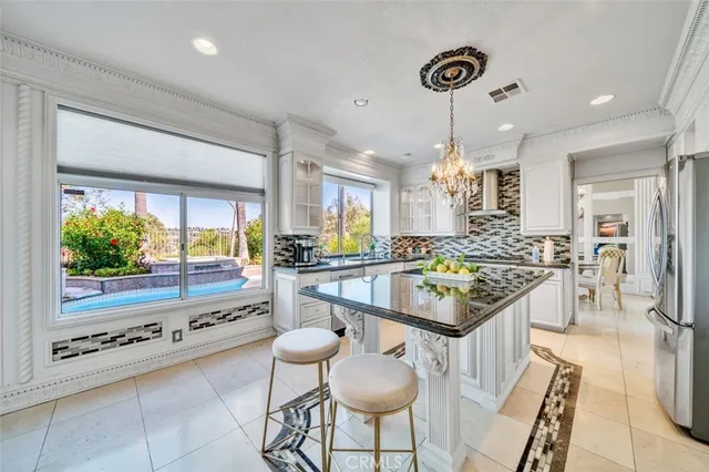 a kitchen with granite countertop kitchen island stainless steel appliances a stove a table and chairs in it