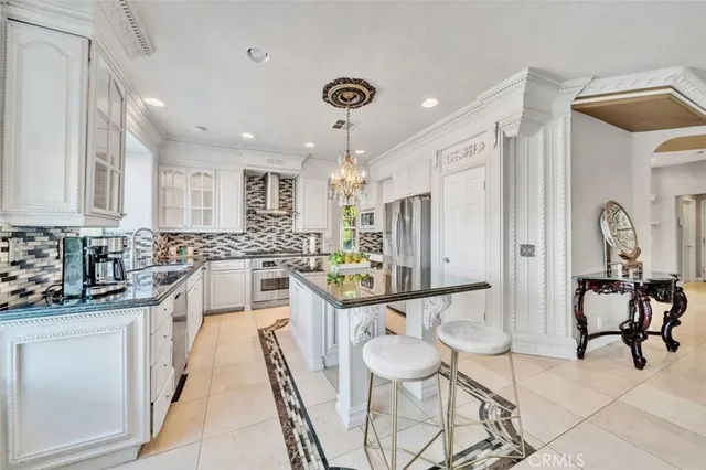 a large white kitchen with a sink and dishwasher a stove top oven with wooden floor