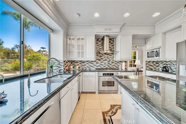 a large kitchen with stainless steel appliances granite countertop a sink and stove