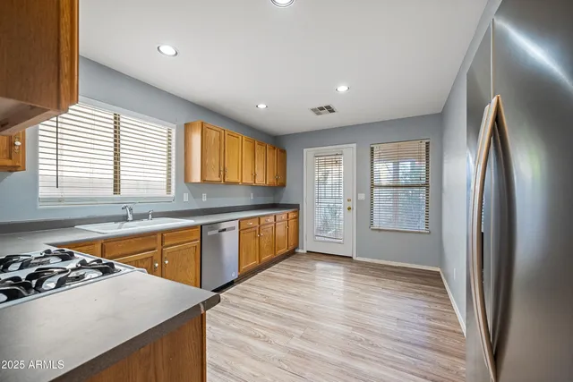 a kitchen with stainless steel appliances granite countertop a sink stove and refrigerator