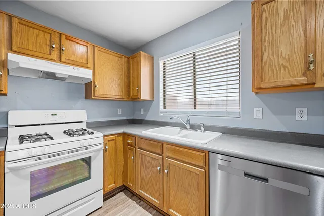 a kitchen with a sink stove top oven and cabinets