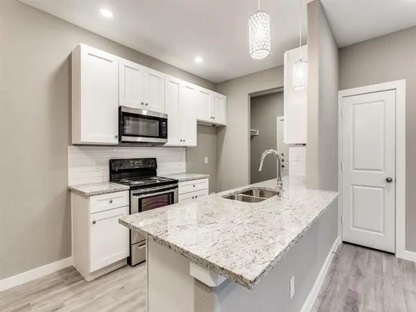 a kitchen with a sink stove top oven and refrigerator