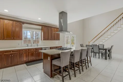 a kitchen with stainless steel appliances kitchen island granite countertop a table and chairs in it