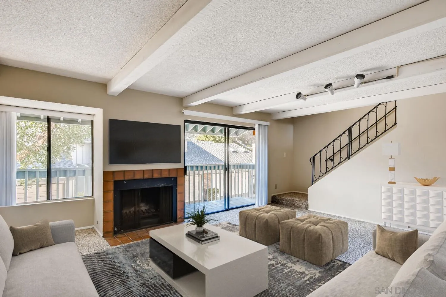 8271 Caminito Modena San Diego, CA 92037 - Photo 1 of 28 a living room with furniture a flat screen tv and a fireplace