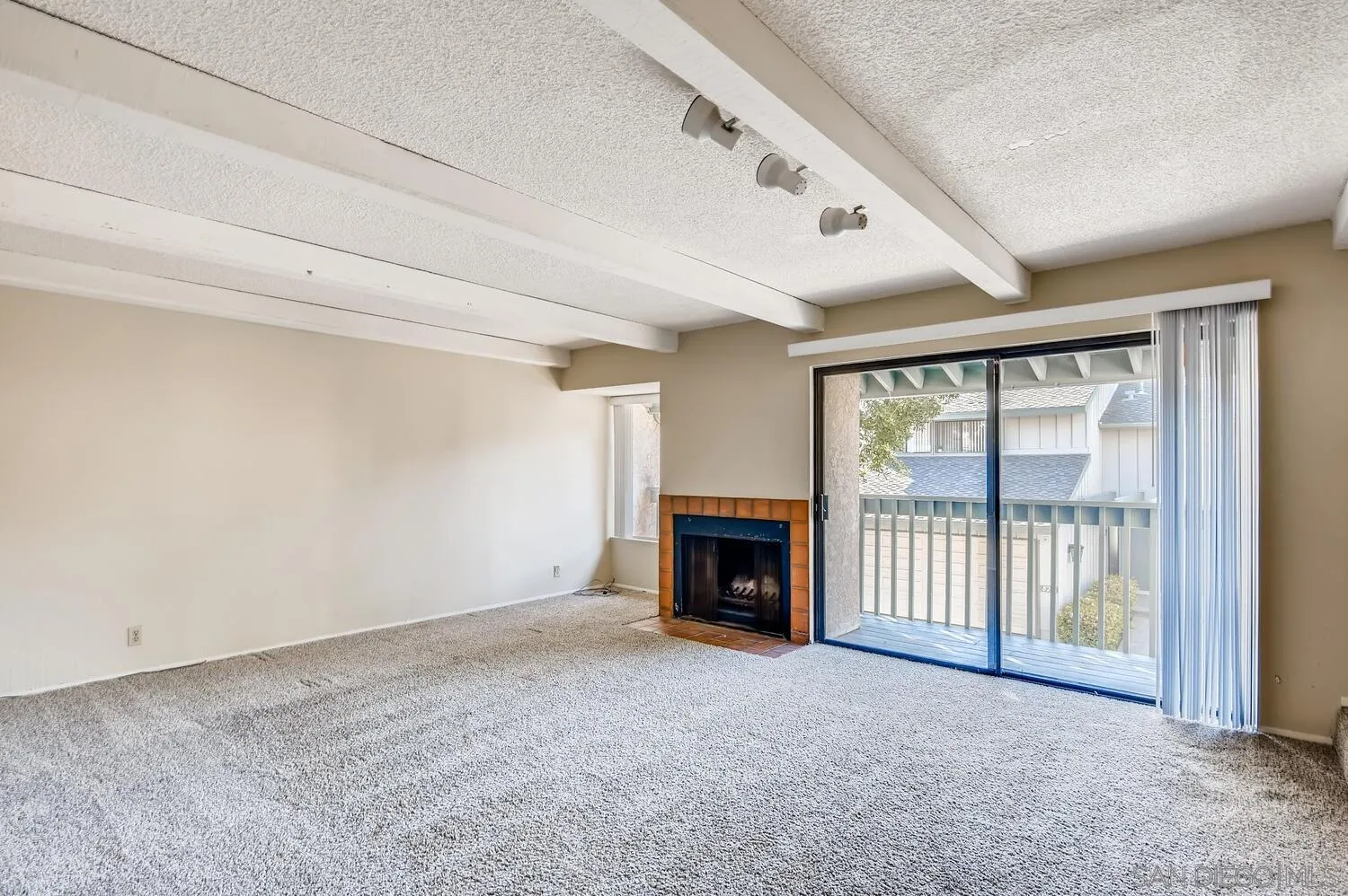 8271 Caminito Modena San Diego, CA 92037 - Photo 21 of 28 a view of an empty room with a fireplace and a window