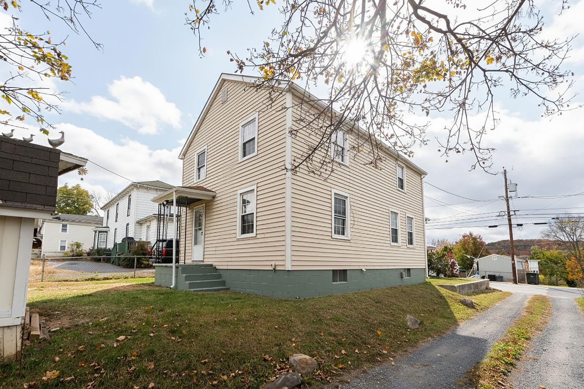 712 Nelson Street Staunton, VA 24401 - Photo 30 of 30 a view of a white house with a yard and lawn chairs under an umbrella