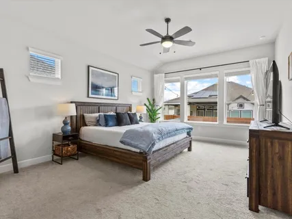 a spacious bedroom with a large bed and a chandelier