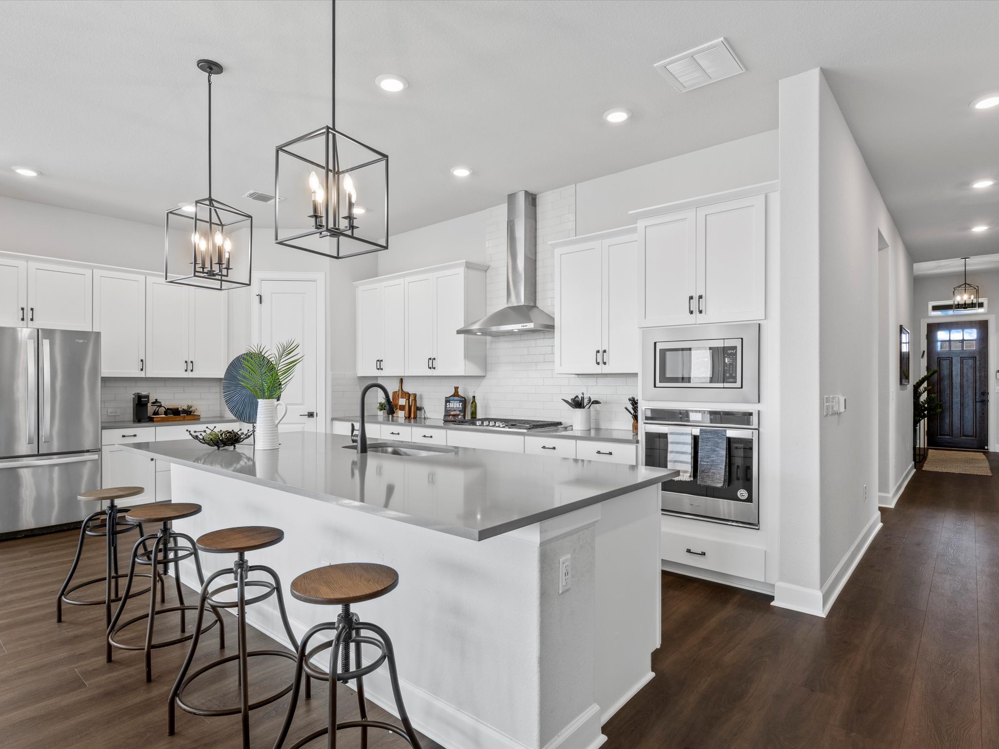 9001 Centurion Path Austin, TX 78744 - Photo 7 of 40 a kitchen with stainless steel appliances kitchen island granite countertop a table chairs and a refrigerator