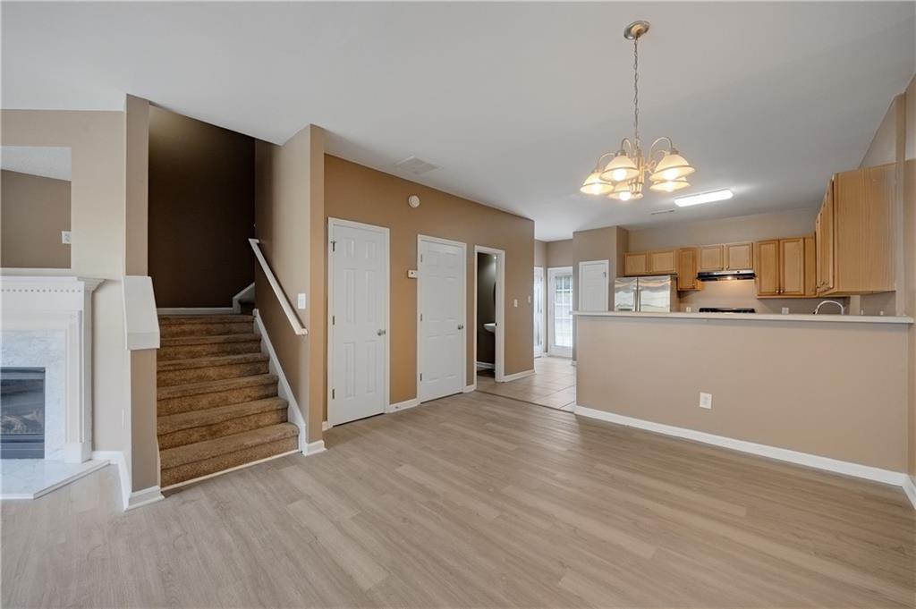 4203 Legacy Square Atlanta, GA 30349 - Photo 11 of 35 a view of a room with wooden floor staircase and a kitchen