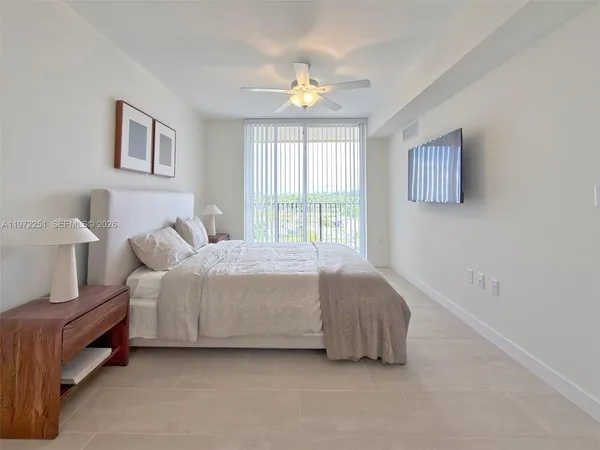 a bedroom with a large bed and a chandelier