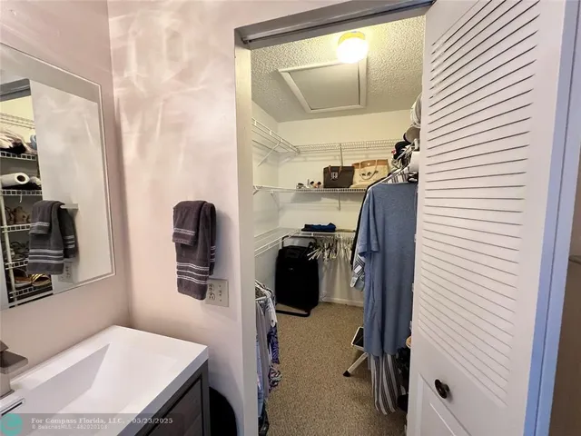 a view of walk in closet with clothes and shoes